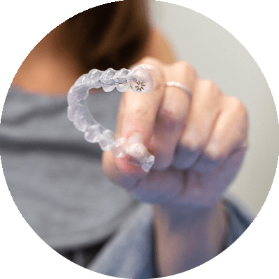 invisalign retainer being held by dental patient